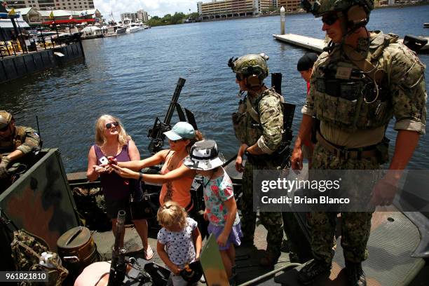 Special operators visit with civilian spectators after returning to the shore in a Special Operations Craft - Riverine after participating in an...