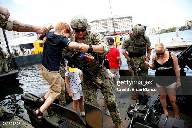 Special operators visit with civilian spectators after returning to the shore in a Special Operations Craft - Riverine after participating in an...