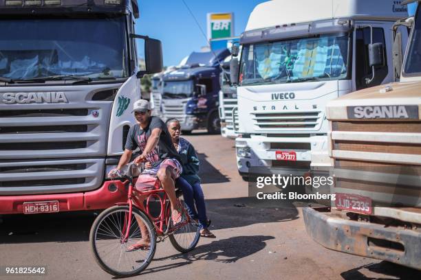 Cyclist navigates around parked trucks on BR 040 highway during a protest against rising fuel prices in Luziania, Brazil, on Wednesday, May 23, 2018....