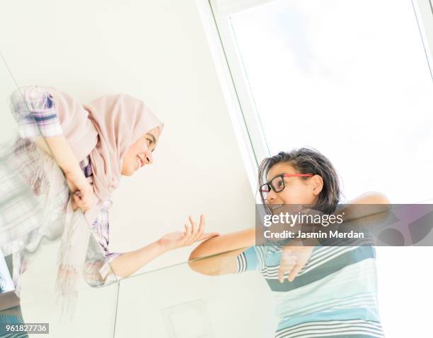 muslim teenage girl and boy having fun - two young arabic children only indoor portrait stock pictures, royalty-free photos & images