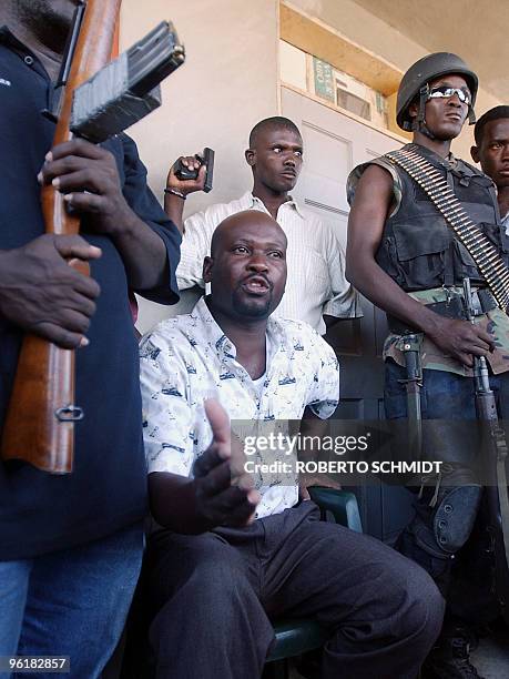 Buteur Metayer , one of the leaders of the Anti-Aristide Resistance Front, is surrounded by armed rebels as he speaks to members of the press in...