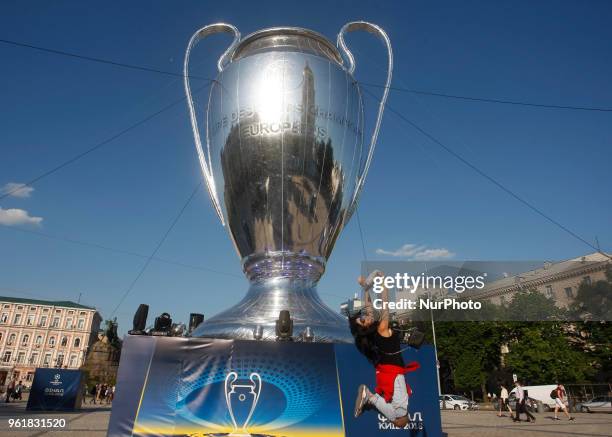 Woman poses for a photo in front of a giant replica of the UEFA Champions League trophy in centr of Kiev, Ukraine, 23 May, 2018.Kiev is preparing for...