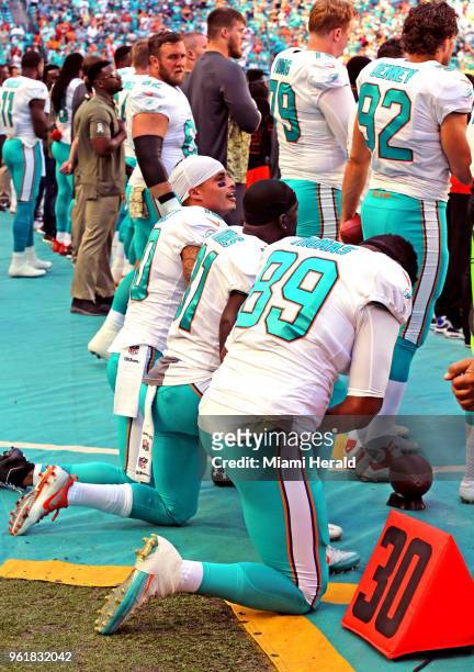 Miami Dolphins Kenny Stills , Michael Thomas , and Julius Thomas kneel during the national anthem as they prepare to play the Tampa Bay Buccaneers on...