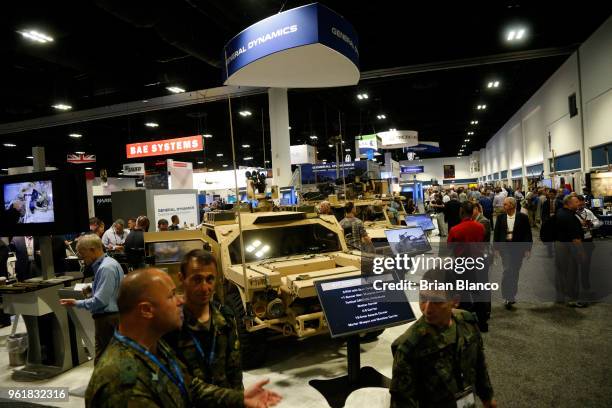 Attendees inspect the latest military technology and gear, including the Flyer 72 Lightweight Ground Mobility Vehicle by General Dynamics, during the...