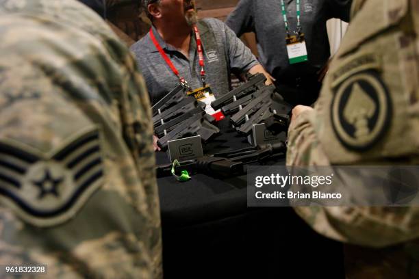 Attendees inspect the latest military technology and gear, including these compact Glock semi-automatic pistols, during the Special Operations Forces...