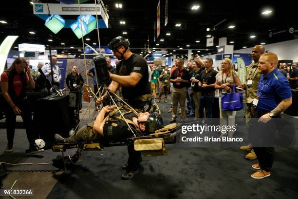 Attendees inspect the latest military technology and gear, including Atlas Devices' APA-5 powered ascender, during the Special Operations Forces...