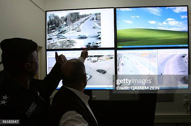 An Iraqi interior ministry representative speaks with an official as they observe security camera feeds in the central shrine city of Najaf on...