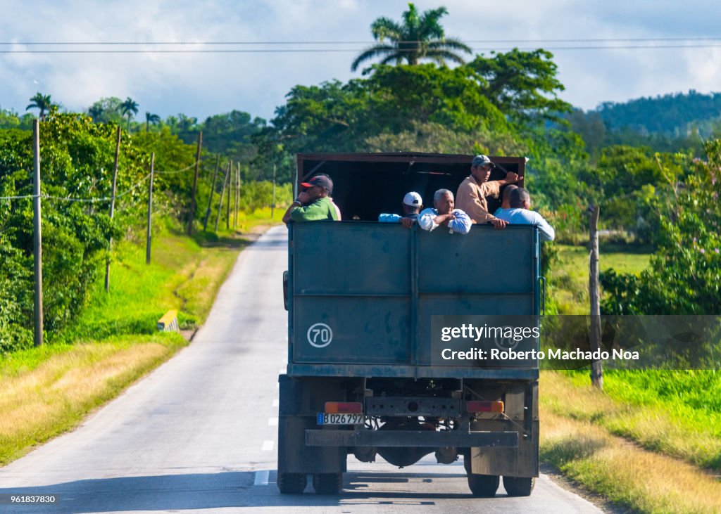 Real people in the back of a truck for transportation in Cuba