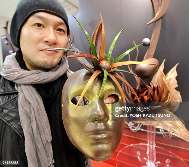 Japanese chocolatier Koichi Izumi displays chocolate masks and opera themed objects at the opening of the Salon du Chocolat at Tokyo's Isetan...