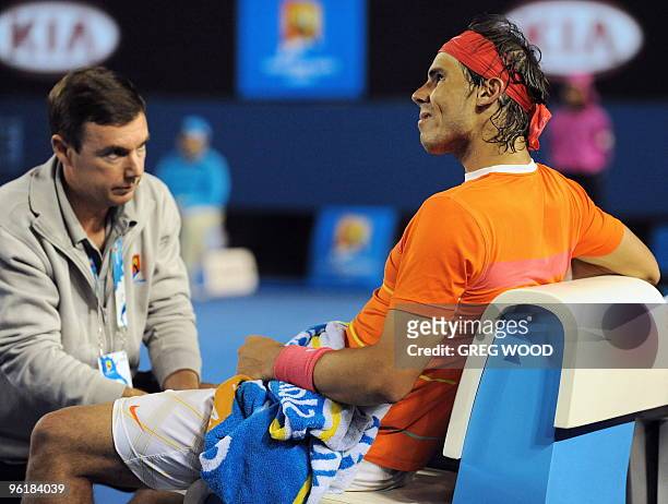 Courtside trainer looks after Rafael Nadal of Spain after an injury to his knee while playing against Andy Murray of Britain in their men's singles...