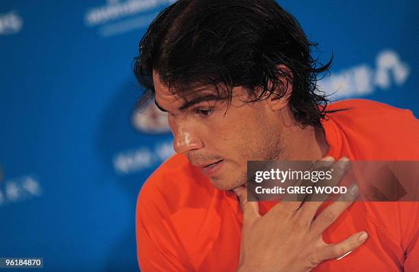 Rafael Nadal of Spain gestures during a press conference after retiring due to injury in his men's singles quarter-final match against Andy Murray of...