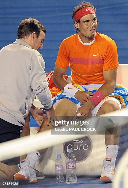 Courtside trainer looks after Rafael Nadal of Spain after an injury to his knee while playing against Andy Murray of Britain in their men's singles...