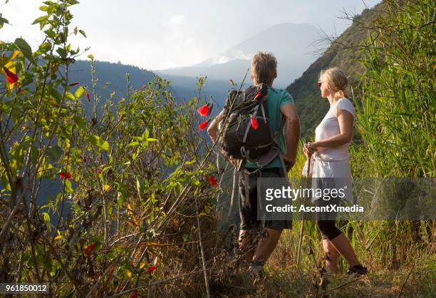 couple hiking below volcano in forest - ecuador stock pictures, royalty-free photos & images