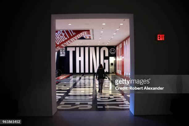 Museum visitor studies an art installation by Barbara Kruger which includes words and phrases printed on the floor and walls at the Hirshhorn Museum...