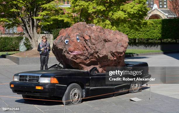 Museum visitor looks at a humorous sculpture by Jimmie Durham titled 'Still Life with Spirit and Xitle' at the Hirshhorn Museum and Sculpture Garden...