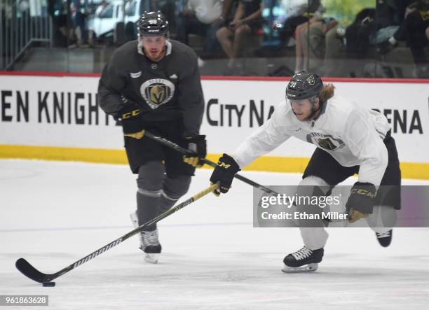 William Karlsson of the Vegas Golden Knights skates with the puck in front of teammate Nate Schmidt during the team's first practice since winning...