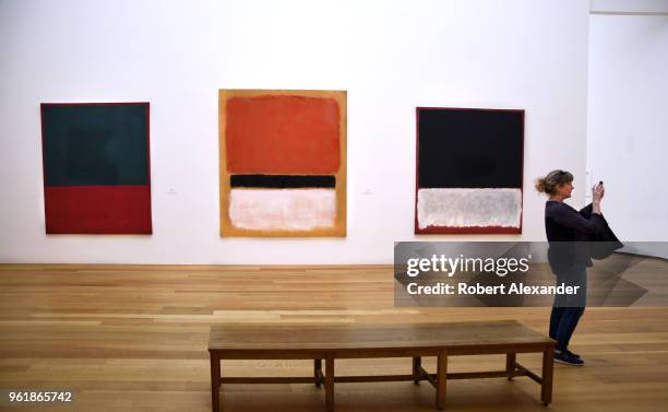 Museum visitor takes a photograph in an exhibit room featuring paintings by Mark Rothko at the National Gallery of Art East Building on the National...