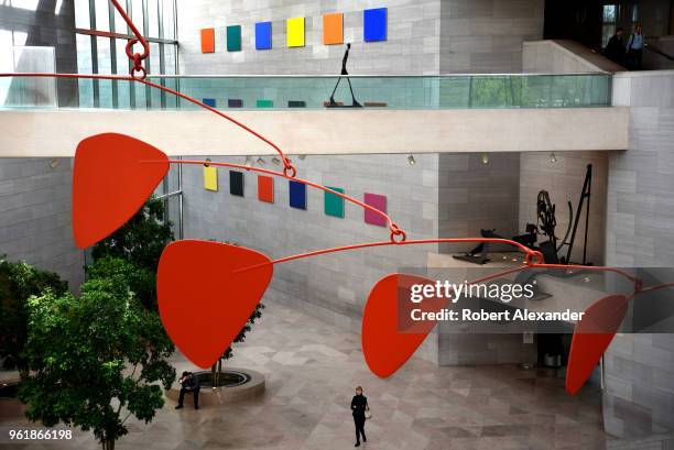 Alexander Calder's untitled aluminum and steel mobile hangs from the ceiling above visitors at the National Gallery of Art East Building on the...