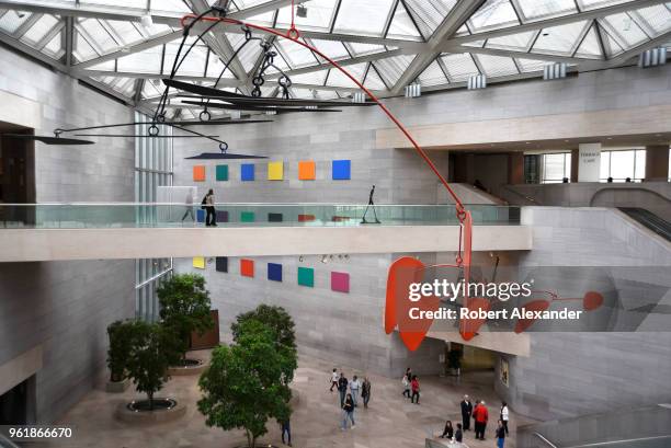 Alexander Calder's untitled aluminum and steel mobile hangs from the ceiling above visitors at the National Gallery of Art East Building on the...