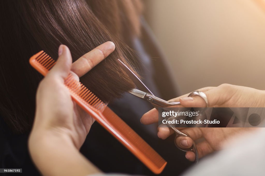 Cropped shot of female client receiving a haircut
