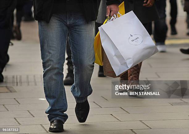 Shopper carries shopping bags along Oxford Street in central London, on January 26, 2010. Britain limped out of its longest ever recession in the...