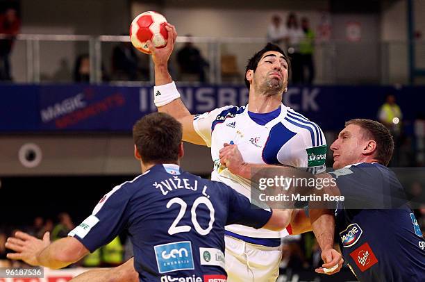 Luka Zvizej and Miladin Kozlina of Slovenia in action with Nikola Karabatic of France during the Men's Handball European main round Group II match...