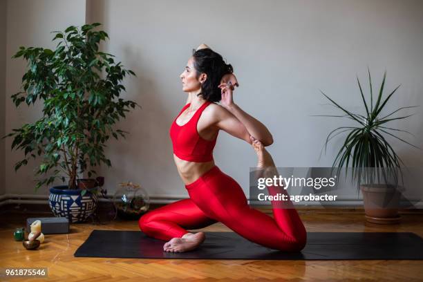 junge attraktive frau in yoga-pose - halber lotussitz stock-fotos und bilder