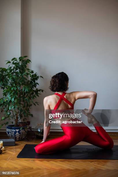 young attractive woman in yoga pose - half lotus position stock pictures, royalty-free photos & images