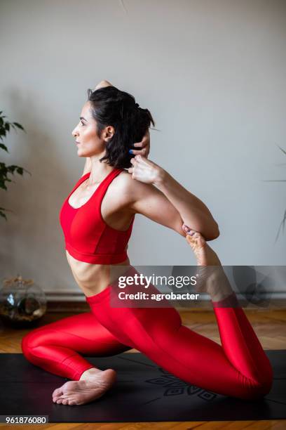 junge attraktive frau in yoga-pose - halber lotussitz stock-fotos und bilder