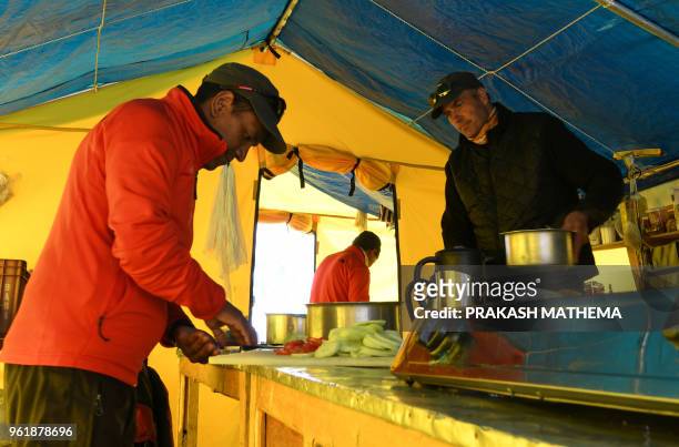 In this photograph taken on April 25 James Perry , a chef at New Zealand-based Adventure Consultants, cooks food in a tent kitchen at Everest base...