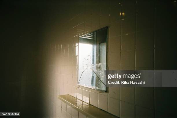 a broken mirror in the toilet beside the seaside - broken mirror stock-fotos und bilder