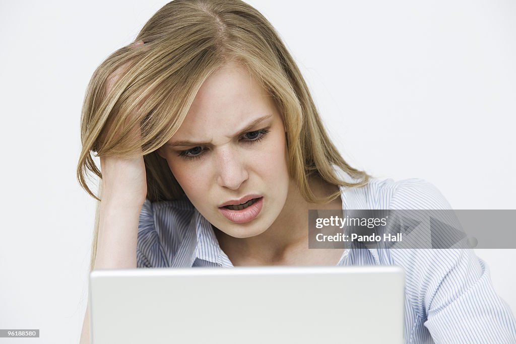 Young woman using laptop with a look of despair