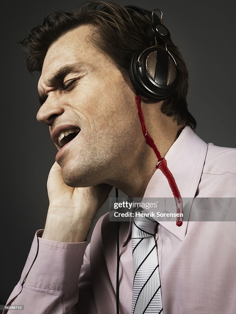 Male with headphones and blood coming out