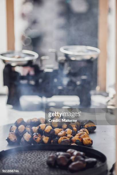 roasted chestnuts in pan with scale in the background. - chispes - fotografias e filmes do acervo