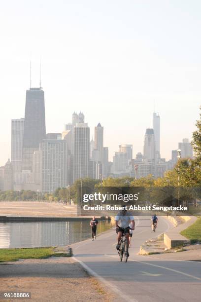 View of the Chicago skyline, taken from the Lakefront trails, with cyclists and joggers visible as they exercise in the morning, ca.2000s. The view...