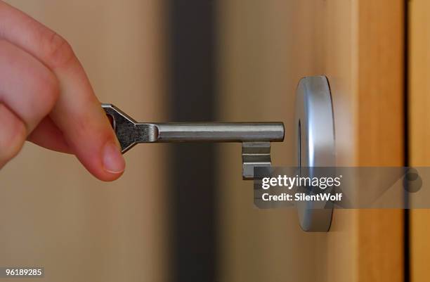 mano agarrando llave - lock fotografías e imágenes de stock