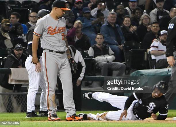 Leury Garcia of the Chicago White Sox lies on the ground after hurting himself stealing third base as Jace Peterson of the Baltimore Orioles looks on...