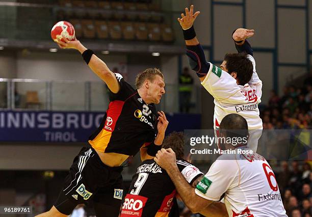 Lars Kaufmann of Germany is challenged by Carlos Prieto and Ruben Garabaya of Spain during the Men's Handball European main round Group II match...