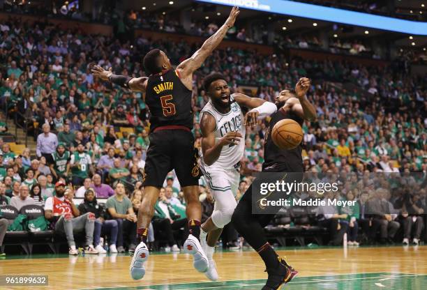 Jaylen Brown of the Boston Celtics loses the ball as he drives to the basket against JR Smith and Tristan Thompson of the Cleveland Cavaliers in the...