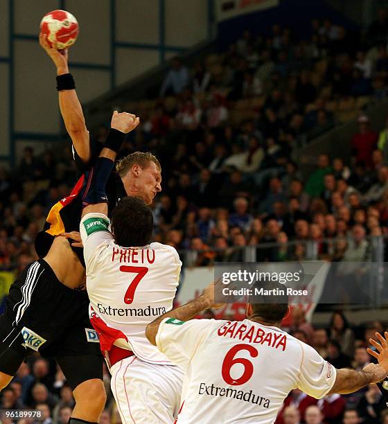 Lars Kaufmann of Germany is challenged by Carlos Prieto and Ruben Garabaya of Spain during the Men's Handball European main round Group II match...