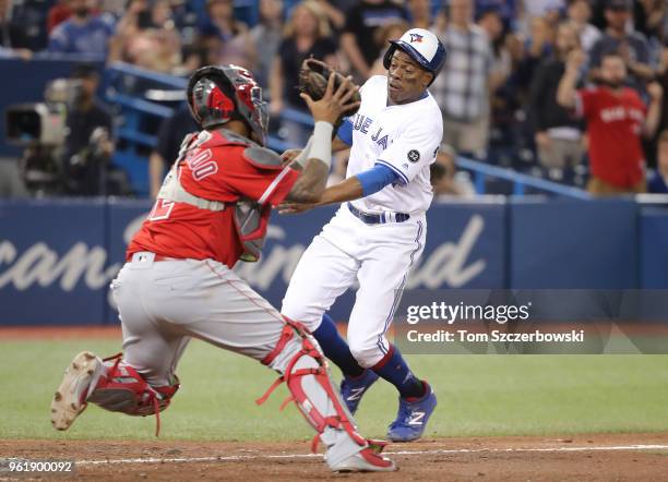 Curtis Granderson of the Toronto Blue Jays is tagged out at home plate by Martin Maldonado of the Los Angeles Angels of Anaheim in the ninth inning...