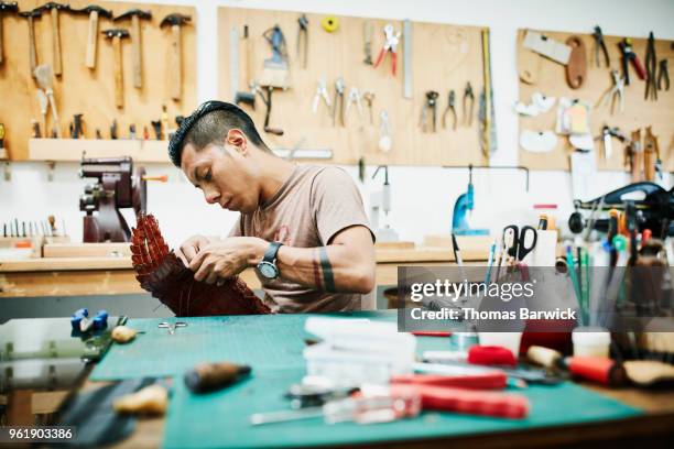 leatherworker hand making purse in workshop - large group of craftsman stock-fotos und bilder