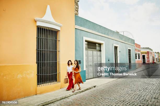 Female friends in discussion while walking through town while shopping on vacation