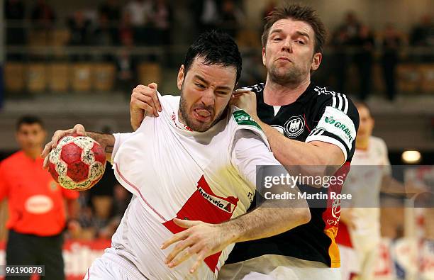 Christian Sprenger of Germany is challenged by Iker Romero of Spain during the Men's Handball European main round Group II match between Germany and...