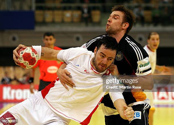 Christian Sprenger of Germany is challenged by Iker Romero of Spain during the Men's Handball European main round Group II match between Germany and...