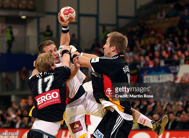 Manuel Spaeth and Lars Kaufmann of Germany challenge Victor Tomas of Spain during the Men's Handball European main round Group II match between...