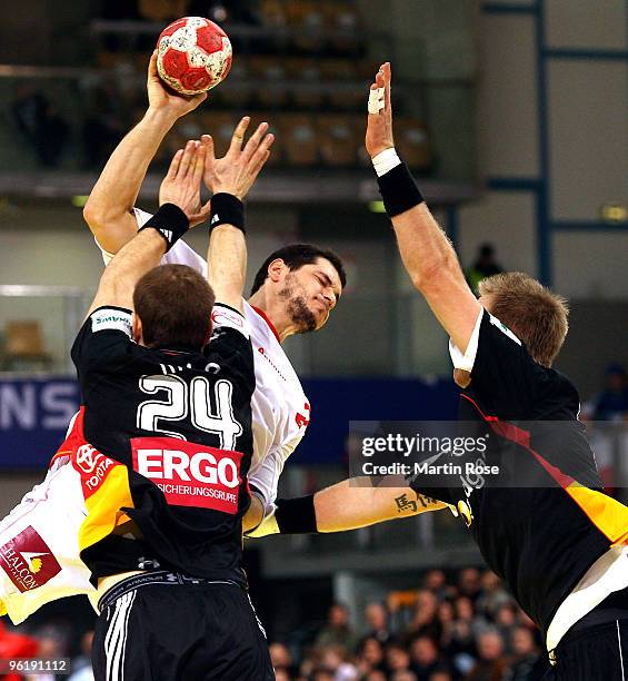 Michael Haass and Lars Kaufmann of Germany chellange Alberto Entrerrios of Spain during the Men's Handball European main round Group II match between...