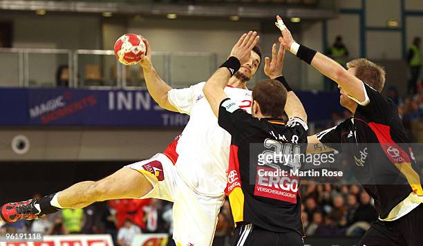 Michael Haass and Lars Kaufmann of Germany challenge Alberto Entrerrios of Spain during the Men's Handball European main round Group II match between...