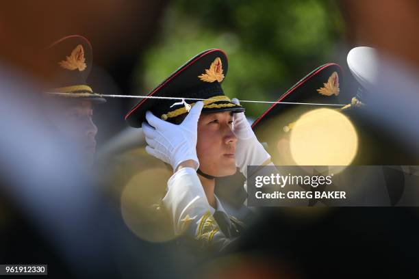 Member of a military honour guard has his cap adjusted before a welcome ceremony for German Chancellor Angela Merkel outside the Great Hall of the...