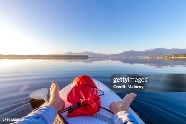 First person view from a paddling board at sunrise. Lake Chiemsee, Chiemgau, Bavaria, Germany